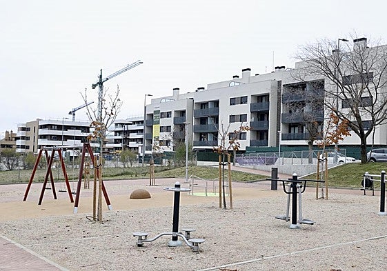 Uno de los nuevos parques inaugurados en Parquesol y, al fondo, una de las promociones en construcción en la ladera sur.