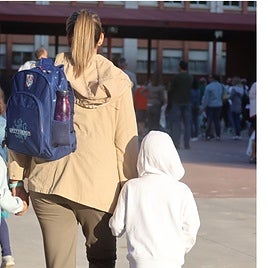 Una mujer acompaña a dos menores a clase en una imagen de archivo.