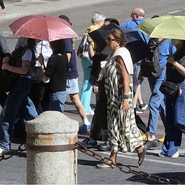 Turistas usan paraguas para protegerse del sol en Segovia.