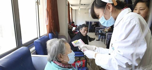 Una enfermera atiende a una paciente en un hospital en Shanghái. / Ray Young (Efe)