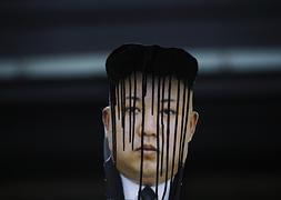 Un cartel de Kim Jong-Un manchado con tinta en una protesta en Corea del Sur. / REUTERS