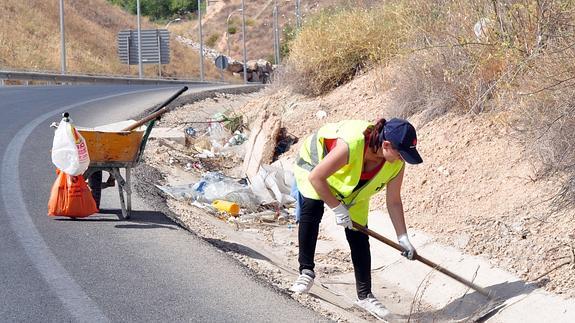 Una mujer trabaja en una carretera de Granada.