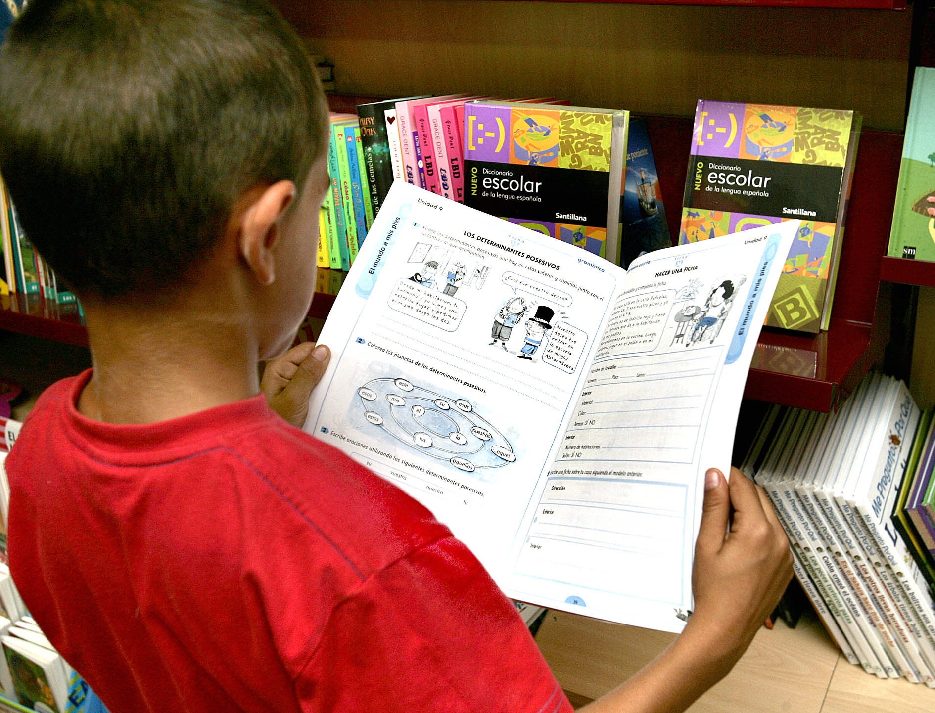 Un niño leyendo un lirbo de texto.