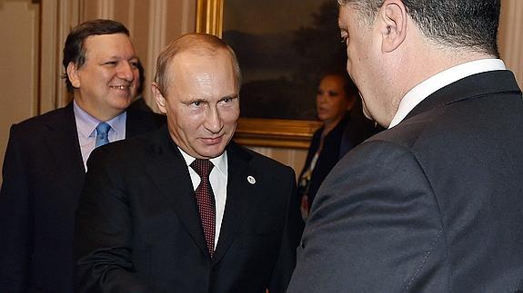 Putin y Poroshenko se estrechan la mano. 