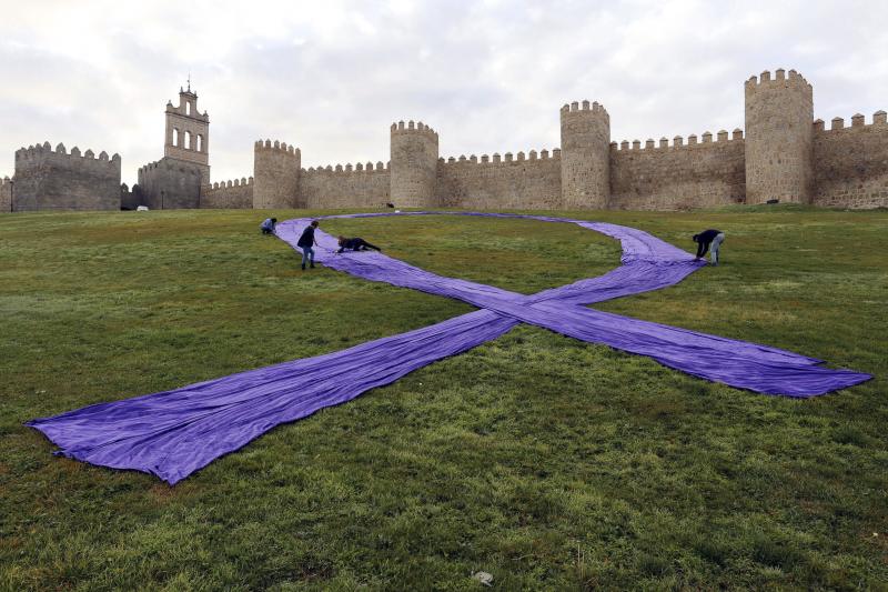 Un gran lazo azul junto a la muralla de Ávila recuerda a las víctimas de la violencia machista. 