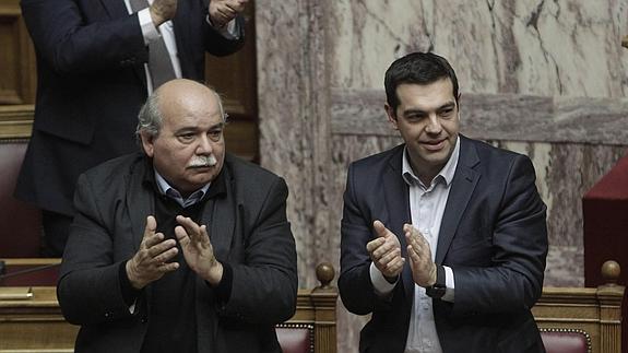 El primer ministro griego Alexis Tsipras (dcha) y el ministro de Interior, Nikos Voutsis, aplauden durante la votación para elegir al nuevo presidente griego.