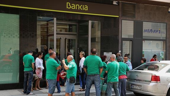 Miembros de la PAH, protestando ante una oficina de Bankia para exigir la eliminacion de la clausula suelo. 