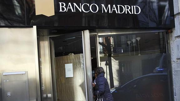 Una mujer entra en una sucursal de Banco Madrid.