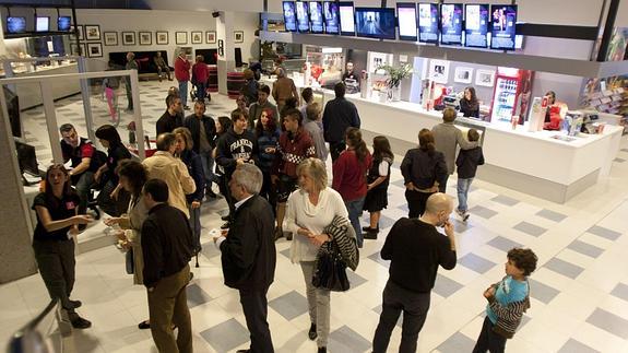 Un grupo de espectadores aguarda para ver una película. 