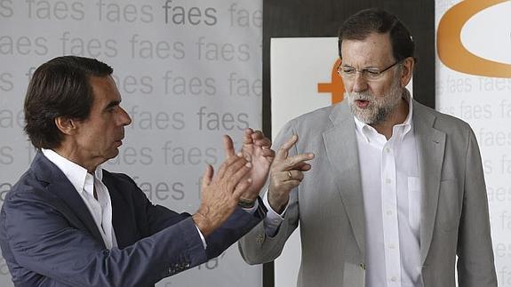 Mariano Rajoy (d), junto a José María Aznar (i).