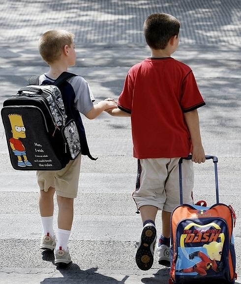 Dos niños van al colegio.