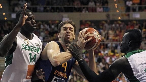 Pau Gasol (c) intenta encestar ante la defensa de los senegaleses Gorgui Sy Dieng (i) y Pape A. Badji.