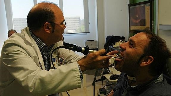 Un médico realizando una prueba a un paciente. 