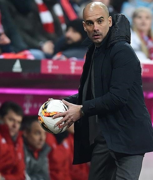 Guardiola sostiene el balón. 