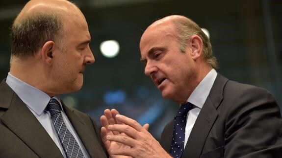 El comisario europeo de Asuntos Económicos, Pierre Moscovici, habla con De Guindos. 