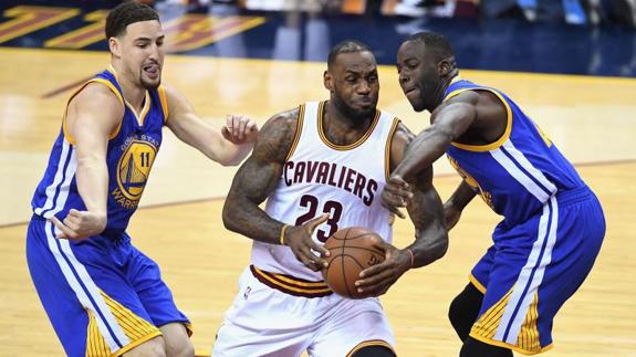 LeBron James, en el centro, ante dos rivales. 