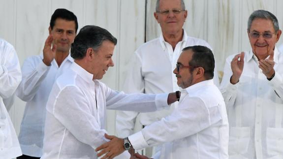 Juan Manuel Santos, presidente de Colombia, y 'Timochenko', líder de las FARC, estrechan sus manos.