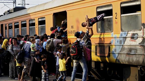 Inmigrantes trepan a un tren en una estación de Macedonia.