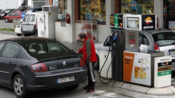 Un hombre echa gasolina en una estación de servicio.