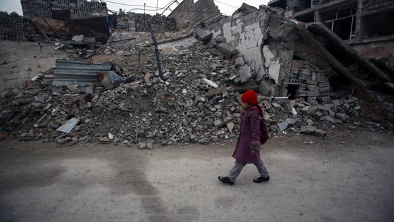 Una niña siria camina junto a casas destruidas en Douma, a las afueras de Damasco. 