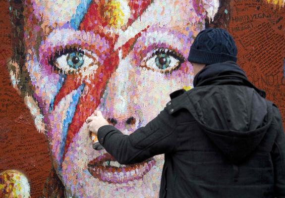 El artista australiano James Cochran, retoca su mural de David Bowie en Brixton, al sur de Londres.
