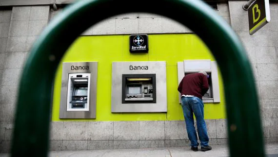Un joven saca dinero de un cajero de Bankia en Madrid. 