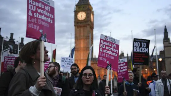 Varias personas manifiestan con pancartas delante del Parlamento en Londres.