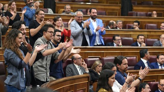 Los diputados de Unidos Podemos aplauden durante el pleno en el Congreso.