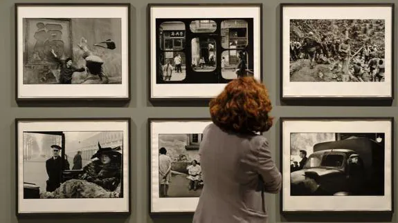 Una espectadora contempla algunas imágenes de grandes fotógrafos captadas con cámaras Leica.