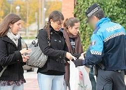 Un agente de la Policía Municipal revisa las bolsas de algunos de los asistentes al 'botellón'. Fuente: Alberto Mingueza