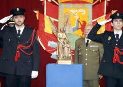 Dos agentes saludan ante la figura del patrón de la Policía Nacional. / Antonio Quintero