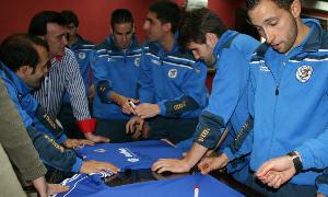 Los jugadores del Cuéllar firman la camiseta que regalaron al alcalde. / Mónica Rico