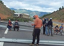 Los mineros, con un camión cruzado en la carretera y sentados sobre los guardarraíles / María Carro