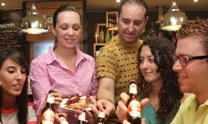 Un grupo de amigos comparte un cubo de cervezas en Quintos y Tapas, en la calle Paraíso. / H. Sastre
