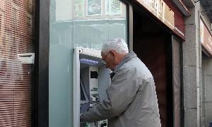 Atilano Soto retira dinero de un cajero de Bankia hace unos días en la capital segoviana. / Antonio de Torre