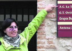 María Eugenia González señala el cartel de la sede la asociación. / C. Catalina