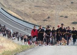 Los participantes inscritos en la marcha 'Puente Entreaguas', durante un tramo del recorrido por la nueva carretera que une Palazuelos de Eresma con los barrios de Parque Robledo y Peñas del Erizo. / A. Tanarro