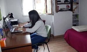 Una estudiante trabaja en su habitación con el portátil. / R. B.