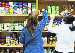 Dos mujeres compran en el supermercado solidario de la asociación. / G. V.