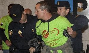 Dos policías sujetan a un sindicalista a las puertas de Printolid durante la madrugada del 29-S. / R. Otazo