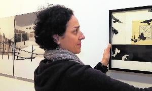 Mónica Gener cuelga una de sus obras en la sala de exposiciones del Palacio de Pimentel. / Henar Sastre