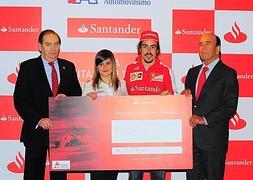 La piloto recibe la Beca de Banco Santander de manos de Alonso. / Efe