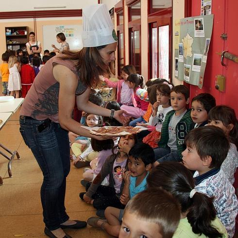 Una de las voluntarias reparte alimentos a los escolares. 