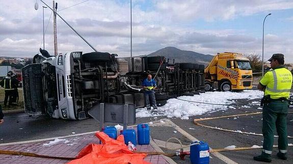 El camión accidentado, volcado en la rotonda de la SG-500 en El Espinar. 