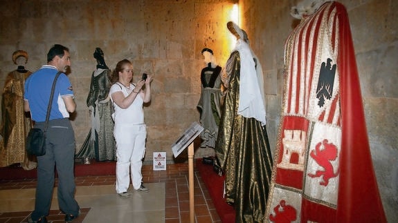 Unos visitantes fotografían los trajes de la reina Isabel. 