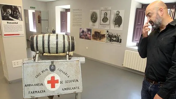 Uno de los responsables de Cruz Roja ante varios objetos de la exposición en el Palacio de Quintanar. 