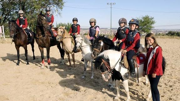 Varios jinetes del Centro de Hípica Fuente el Sol posan con sus caballos.