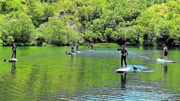 Un grupo de personas practica 'stand up paddle' en el embalse alavés de Sobrón. 