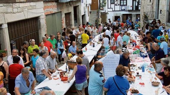 Mientras unos hacían cola para recoger la carne (fila de la izquierda), otros ya iban preparando la mesa donde se iban a situar para merendar. 