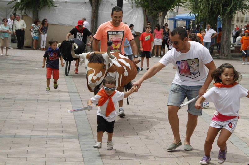 Niños y adultos corren delante de los astados de cartón piedra. 